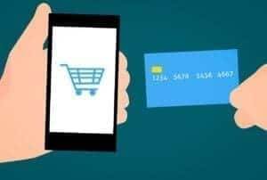 The concept of E-Commerce where a phone with a shopping cart icon and a credit card.