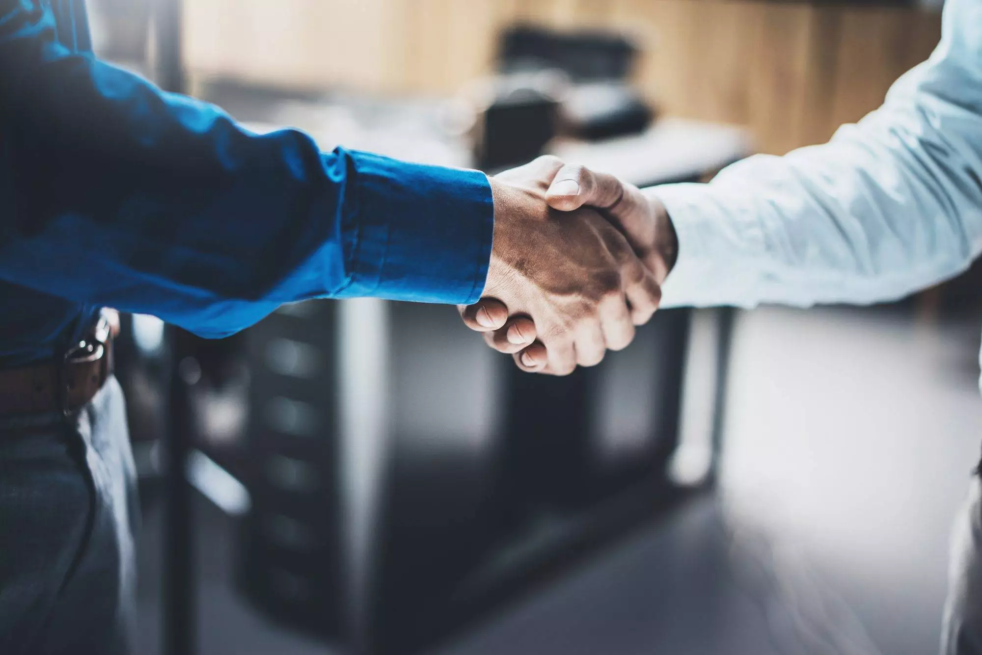 Business partnership handshake concept.Closeup photo of two businessmans handshaking process.Successful deal after great meeting.Horizontal, blurred background.