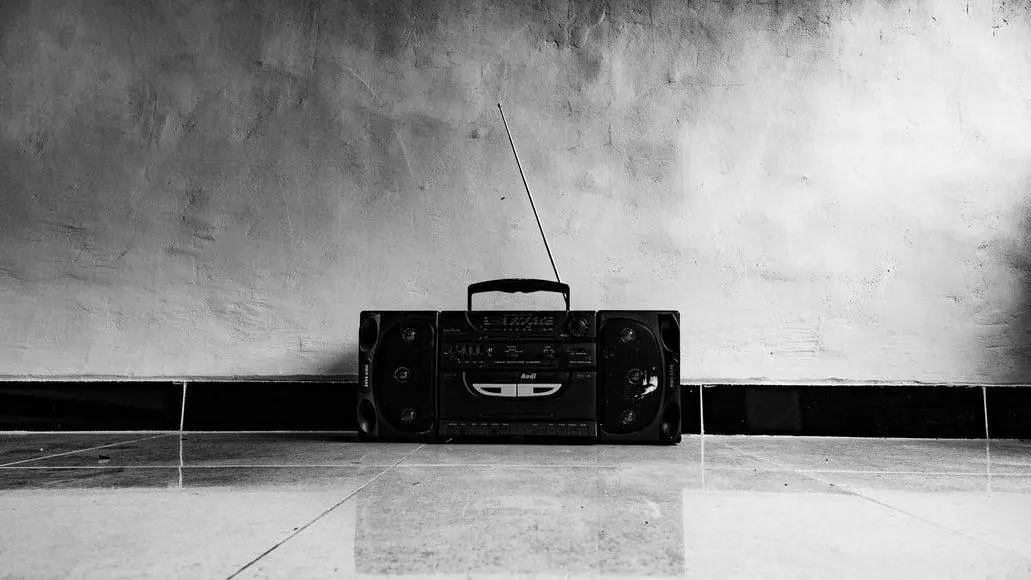 An old black radio in a black and white background showing American radio history.